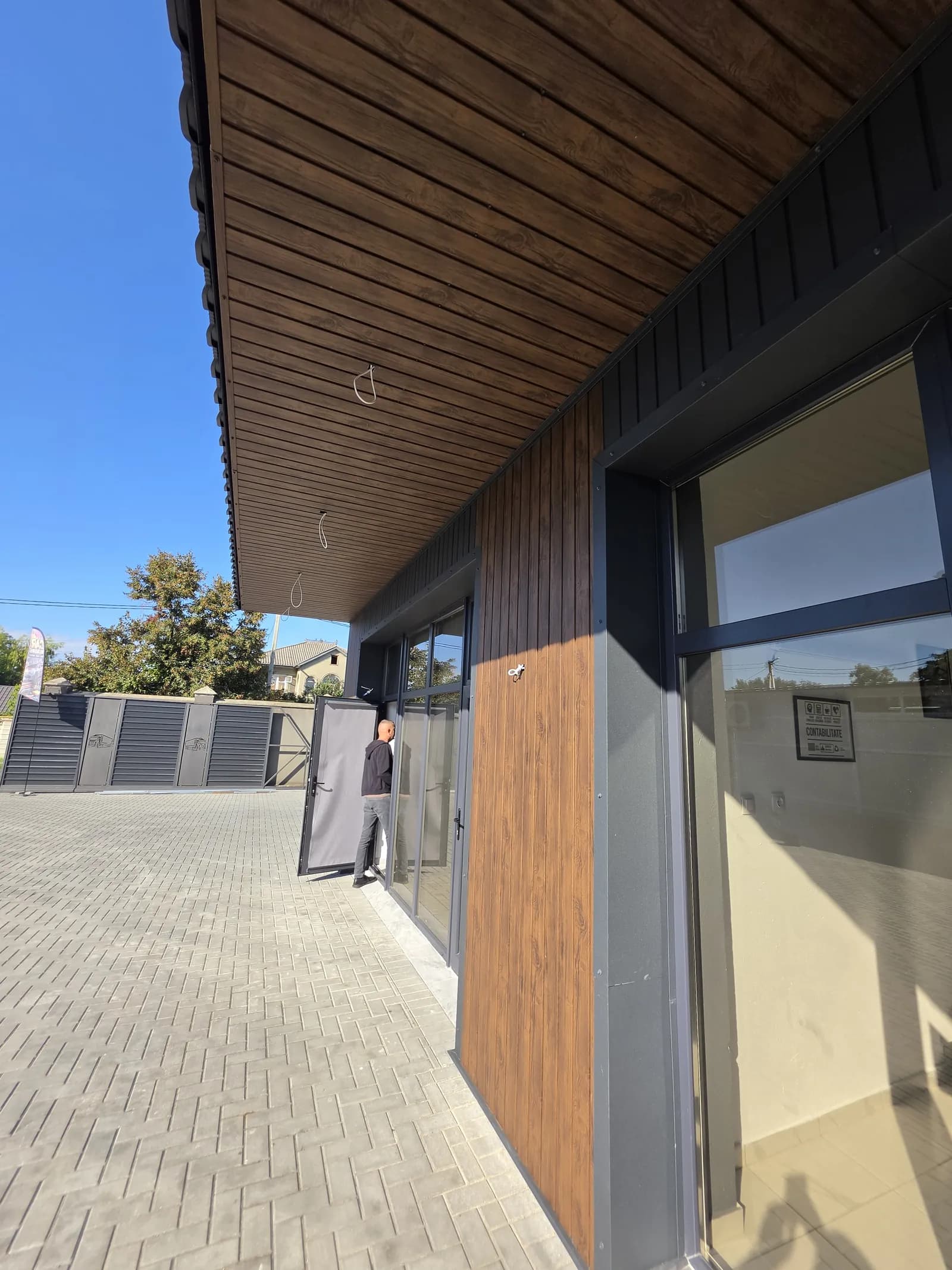 Tavanul de sub ieșitura acoperișului, placat cu soffit lemn închis